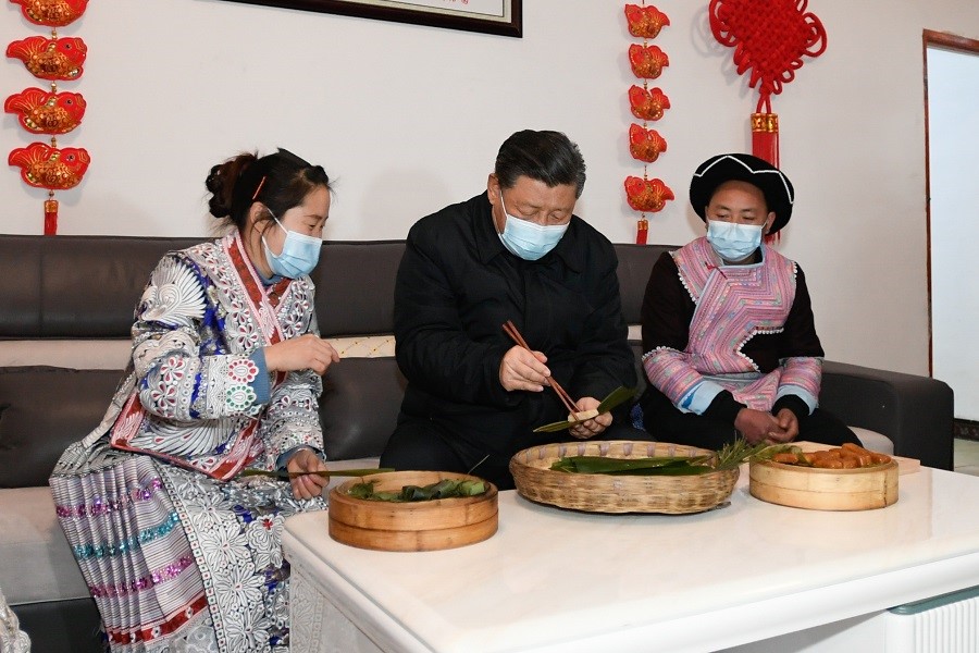2021年2月3日下午，習近平在貴州畢節(jié)市黔西縣新仁苗族鄉(xiāng)化屋村苗族村民趙玉學家，同一家人邊聊家常邊制作當地傳統節(jié)日食品黃粑。新華社記者 李學仁 攝
