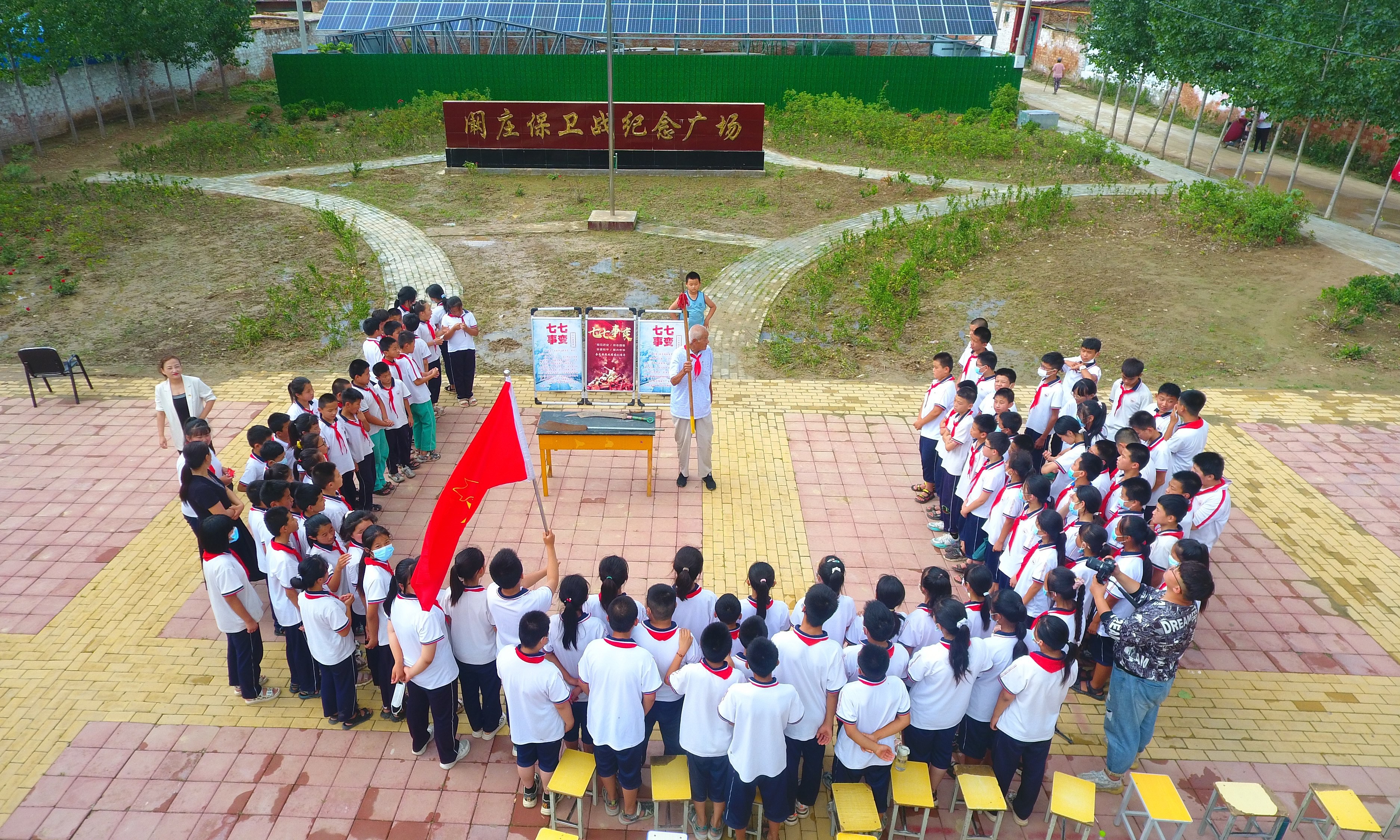 2022年7月6日，山東省聊城市，在茌平區(qū)菜屯鎮(zhèn)闞莊村的闞莊保衛(wèi)戰(zhàn)紀(jì)念廣場(chǎng)，闞莊保衛(wèi)戰(zhàn)親歷者王光木老人，為小學(xué)生們講述抗戰(zhàn)故事，展示大刀、長(zhǎng)矛。